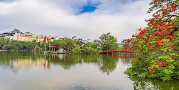 Hoan Kiem Lake in Hanoi at sunrise with a temple in the background.