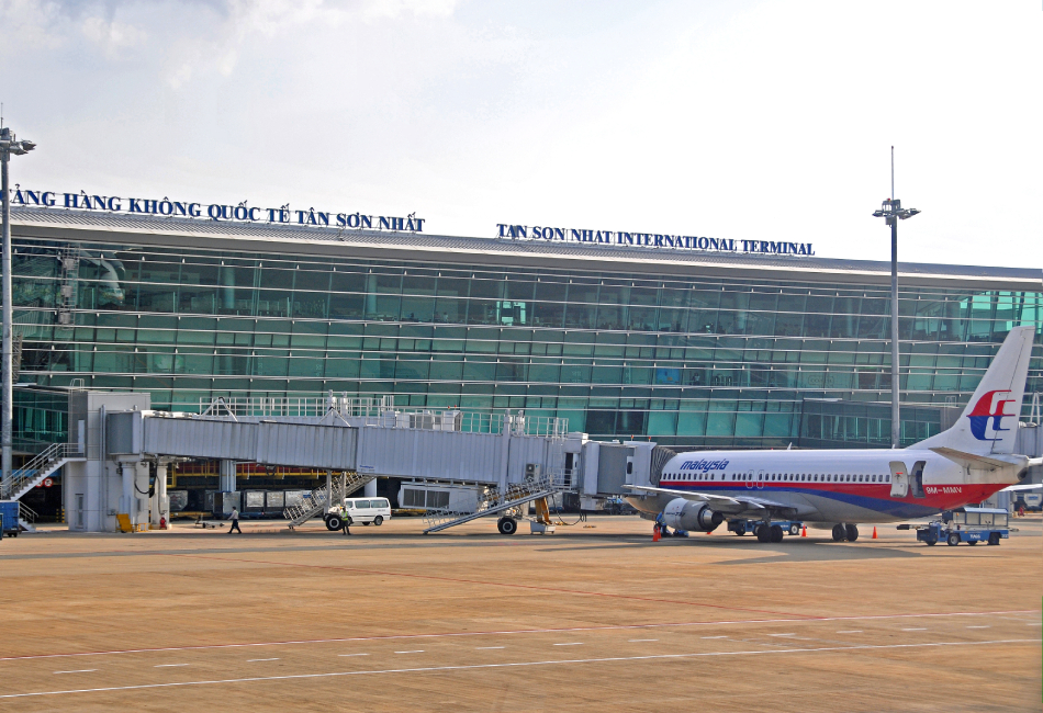 Tan Son Nhat International Airport terminal in Ho Chi Minh City with airplanes parked on the tarmac.- travel between Hanoi and Ho Chi Minh City